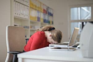woman-sitting-on-chair-while-leaning-on-laptop-3791136 træt kvinde