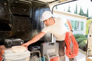 young electrician worker taking tools out of professional truck van håndværker i bil